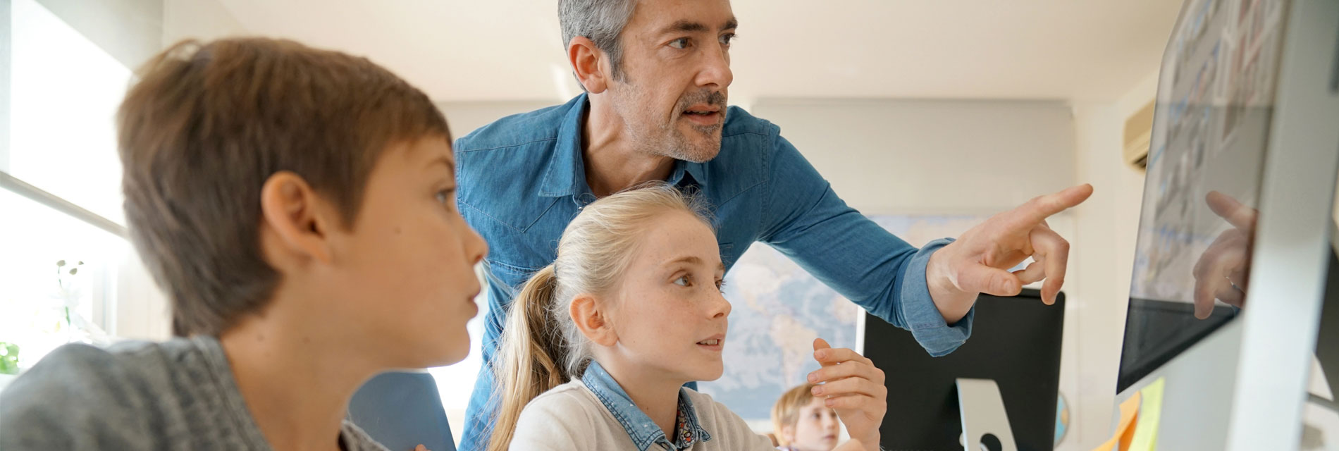 A teacher showing pupils somehting on computer screen